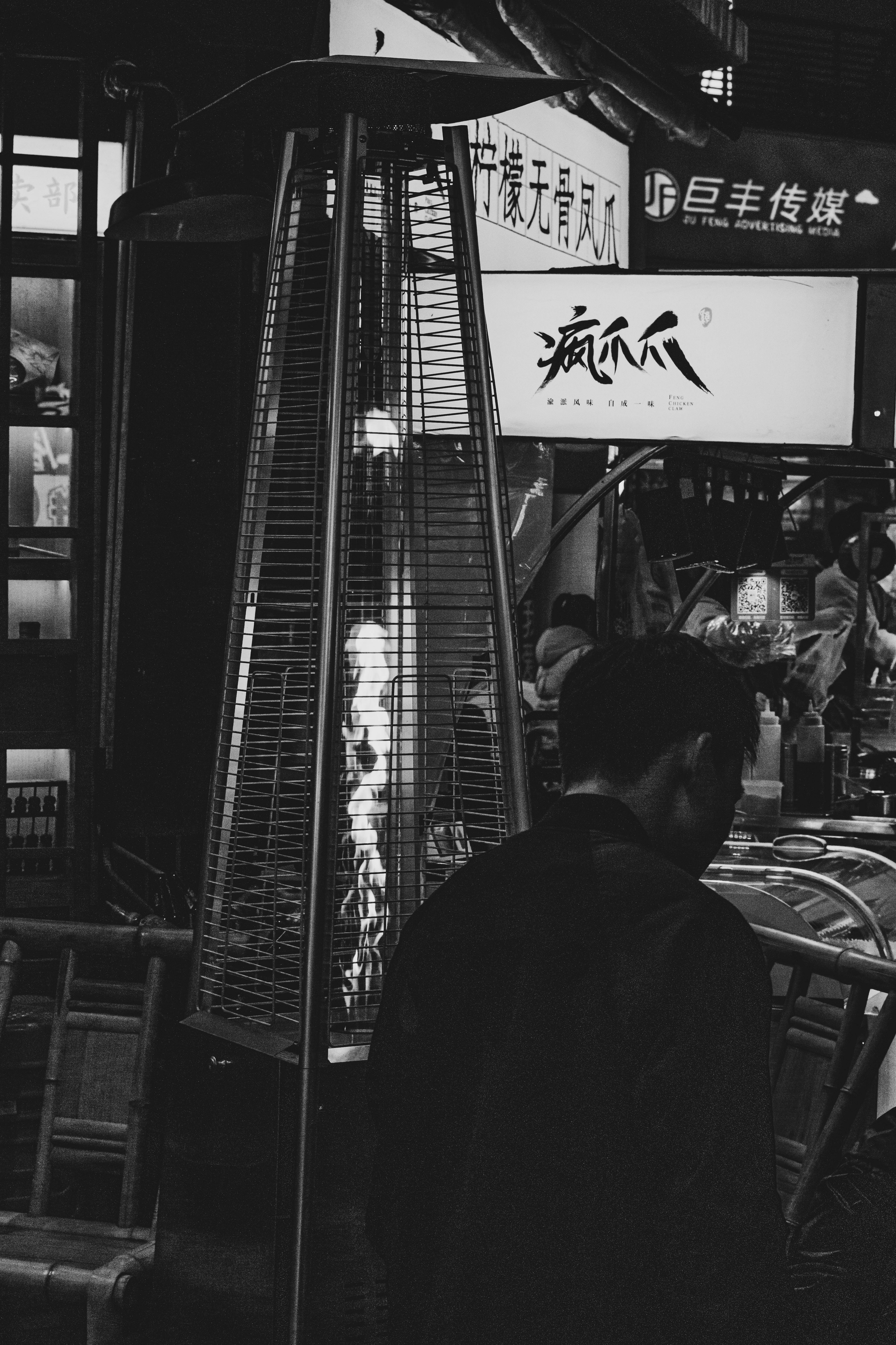 man standing by a grated flame