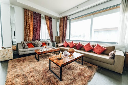 Brown Leather Sofa With Red Pillows Near Windows