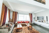 客厅明亮时尚，配有充满活力的窗帘和枕头、现代沙发及家庭娱乐设施