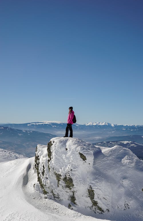 Female Hiker Standing on a Snowcapped Peak