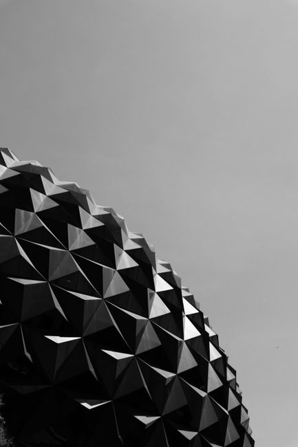 Black and white image of modern geometric architecture with a striking dome design.