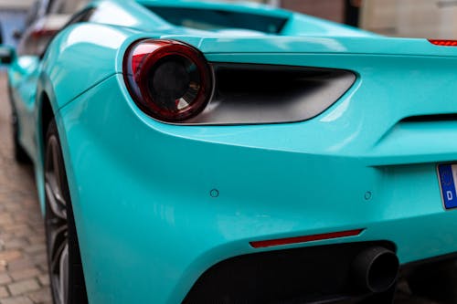A turquoise ferrari sports car is parked on the street