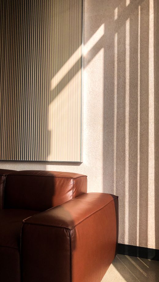 Tan leather chair against a fluted wall — photo by &Ccedil;isel Bozar on Pexels