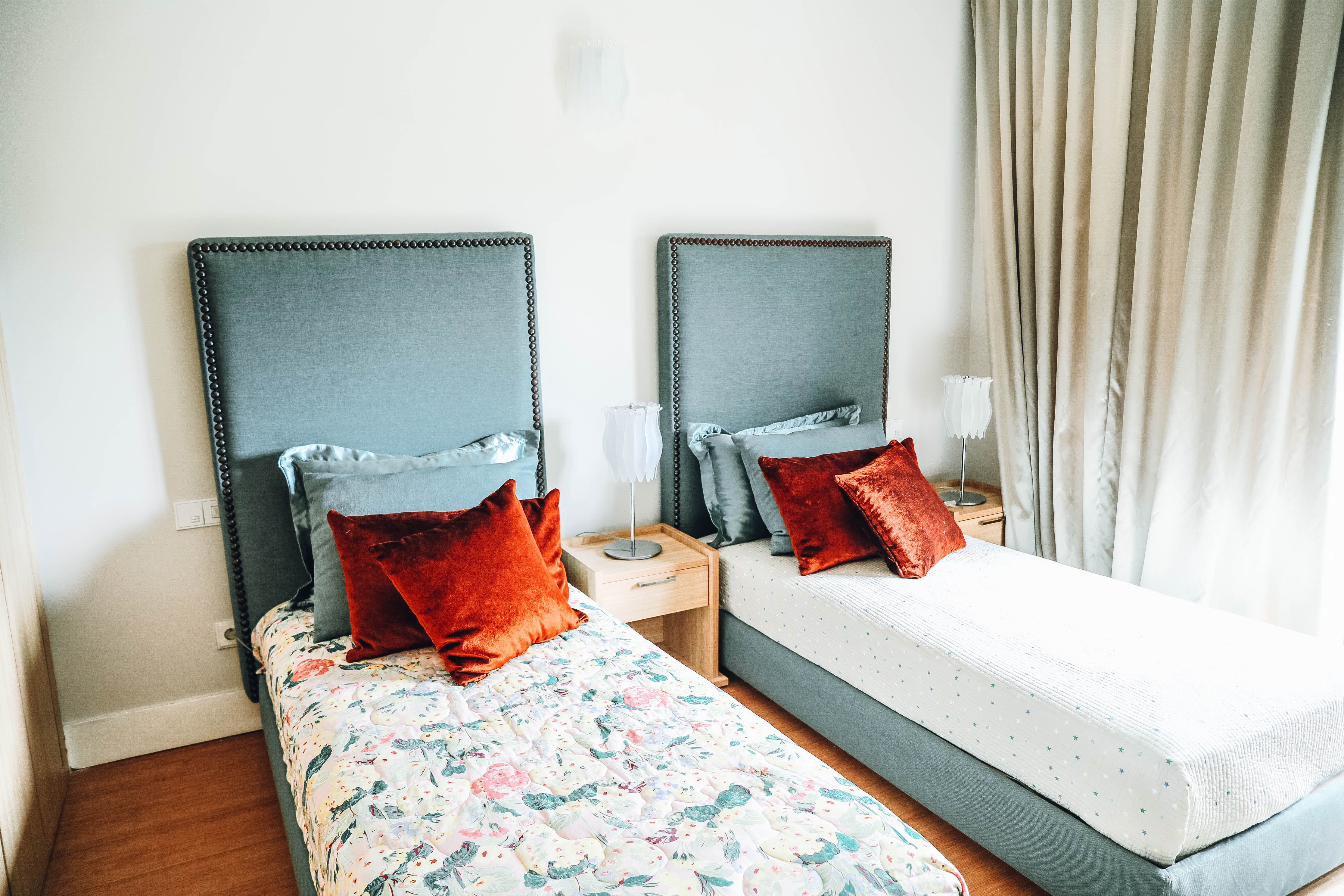 Two separate single beds in a bright, well-designed bedroom
