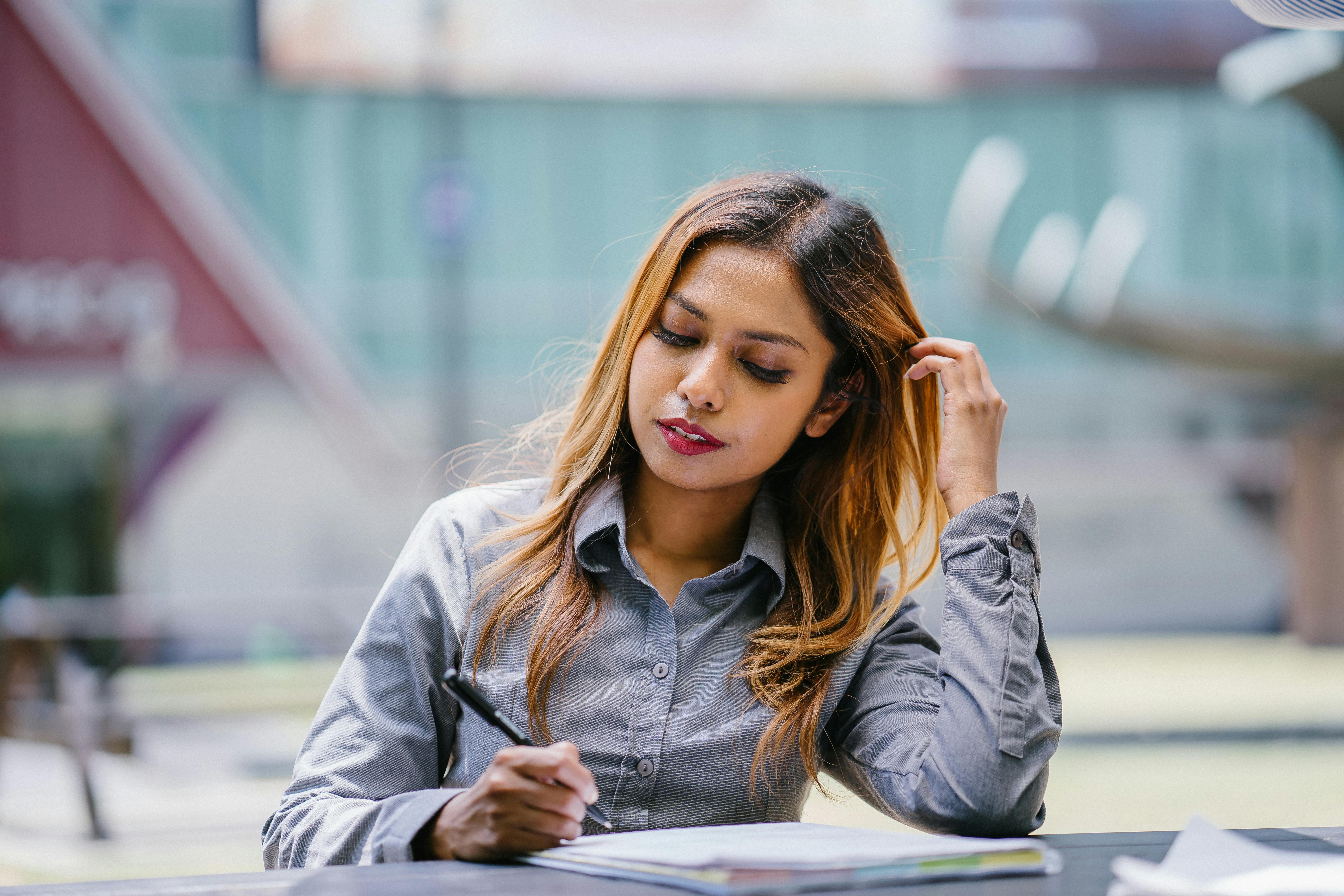 sitting woman reading and holding pen