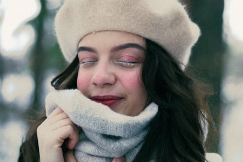 Free Close-up of a Young Woman Wearing a Hat and a Scarf Standing Outside in Winter  Stock Photo