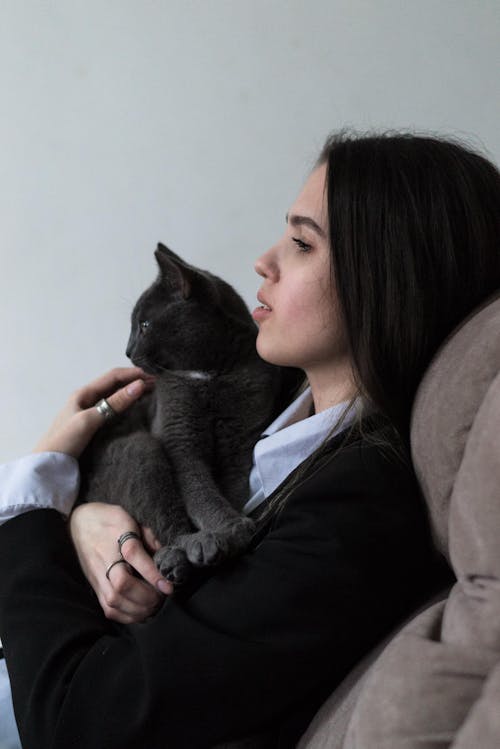 Woman Sitting and Hugging Cat