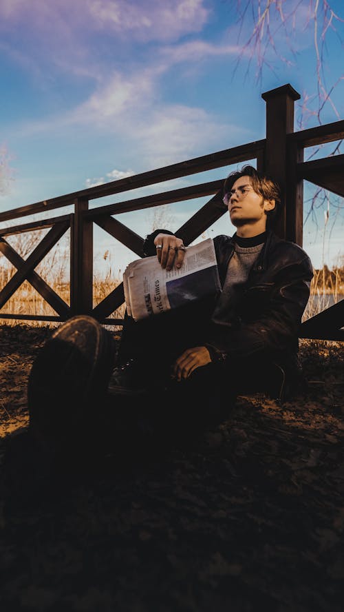 A man sitting on a bench reading a book