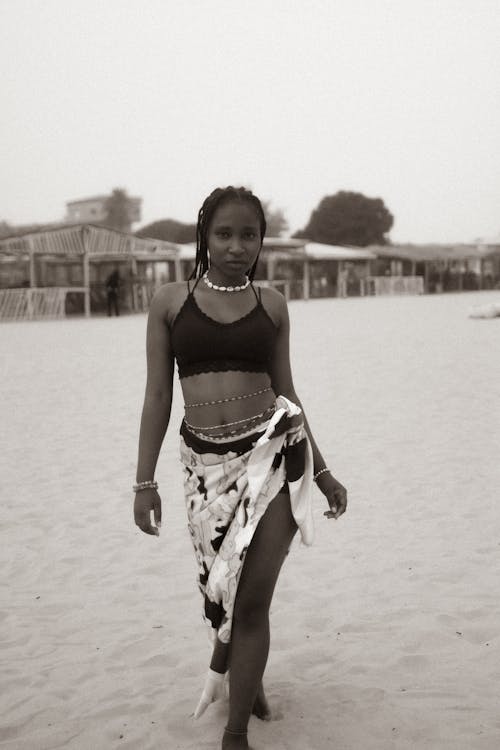 Black and White Photo of a Young Woman Walking on a Beach 