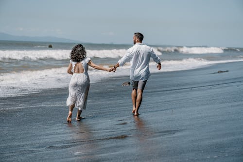 A man and woman running on the beach