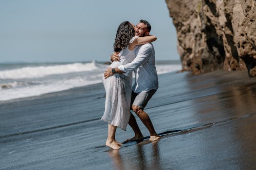Man Hugging Woman on Sea Shore