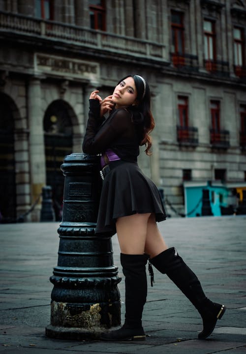 Woman Posing in Black Dress and Boots