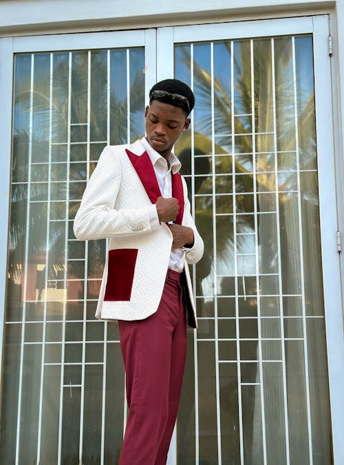 A man in a white suit and red pants