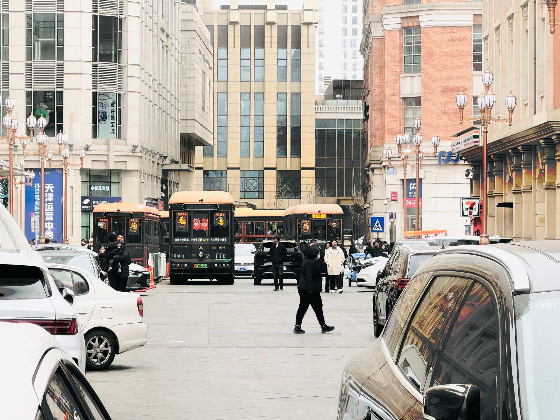 Bustling street in Tianjin, China featuring people, cars, and buses in a vibrant urban setting.