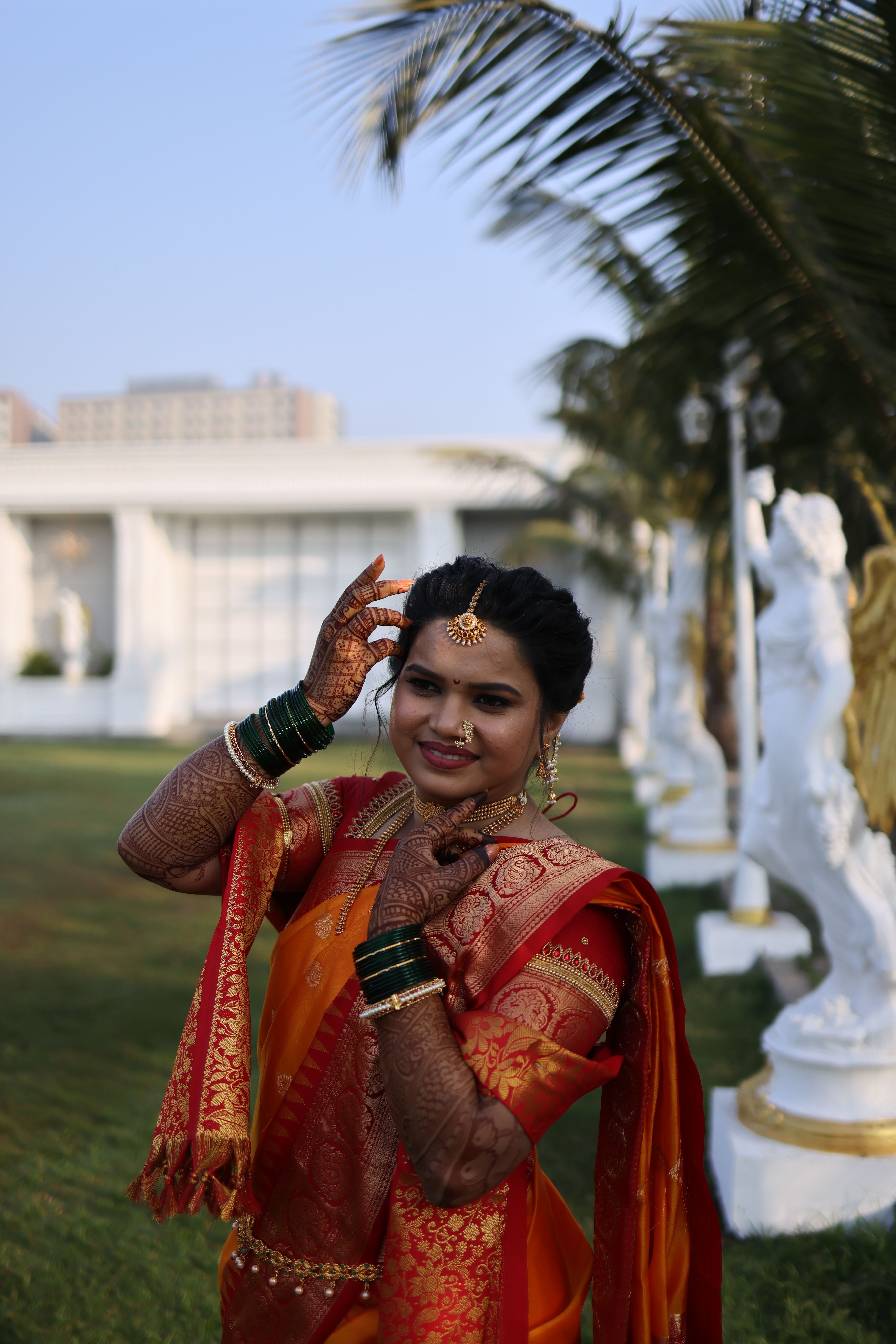 A woman in an orange and red sari is posing for the camera · Free Stock ...