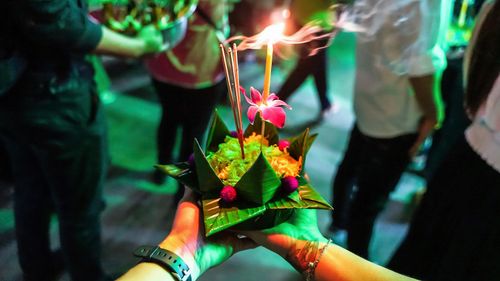 Free Capturing the vibrant tradition of Loy Krathong with a floating offering adorned with a candle and flowers. Stock Photo