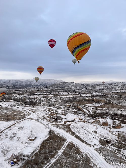 Hot air balloons flying over a snowy landscape