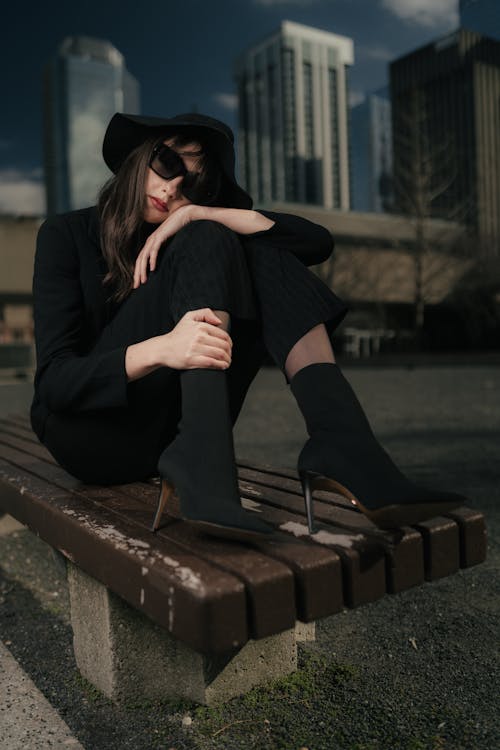 A woman in black hat sitting on a bench