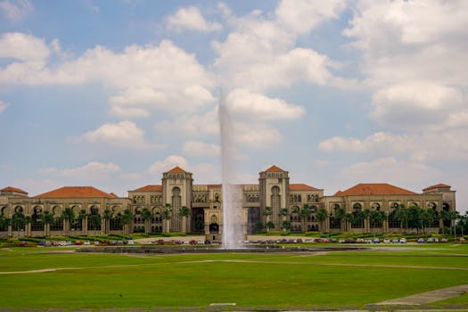 View of Sultan Iskandar Building with fountain in a garden setting, Malaysia.