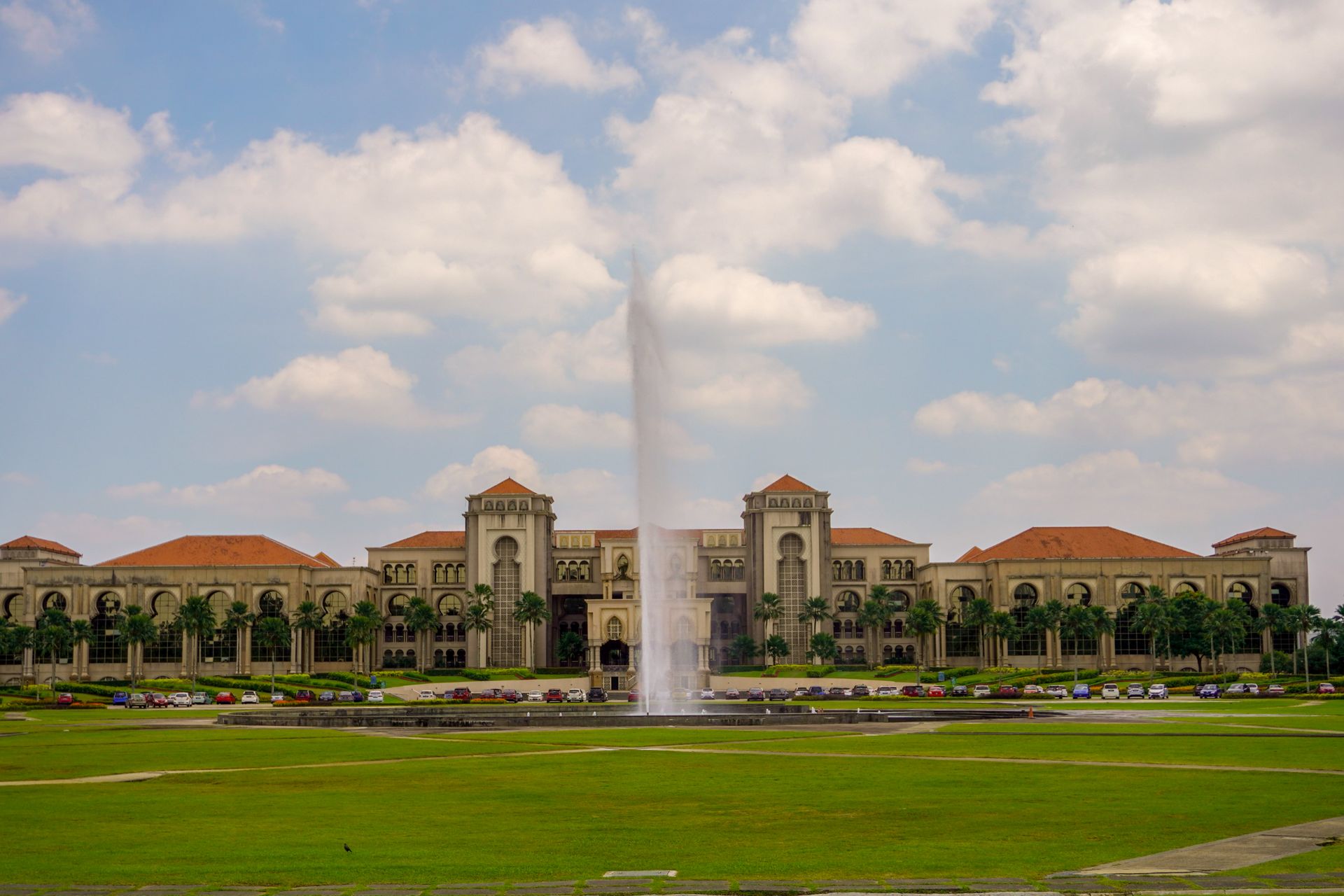 View of Sultan Iskandar Building with fountain in a garden setting, Malaysia.
