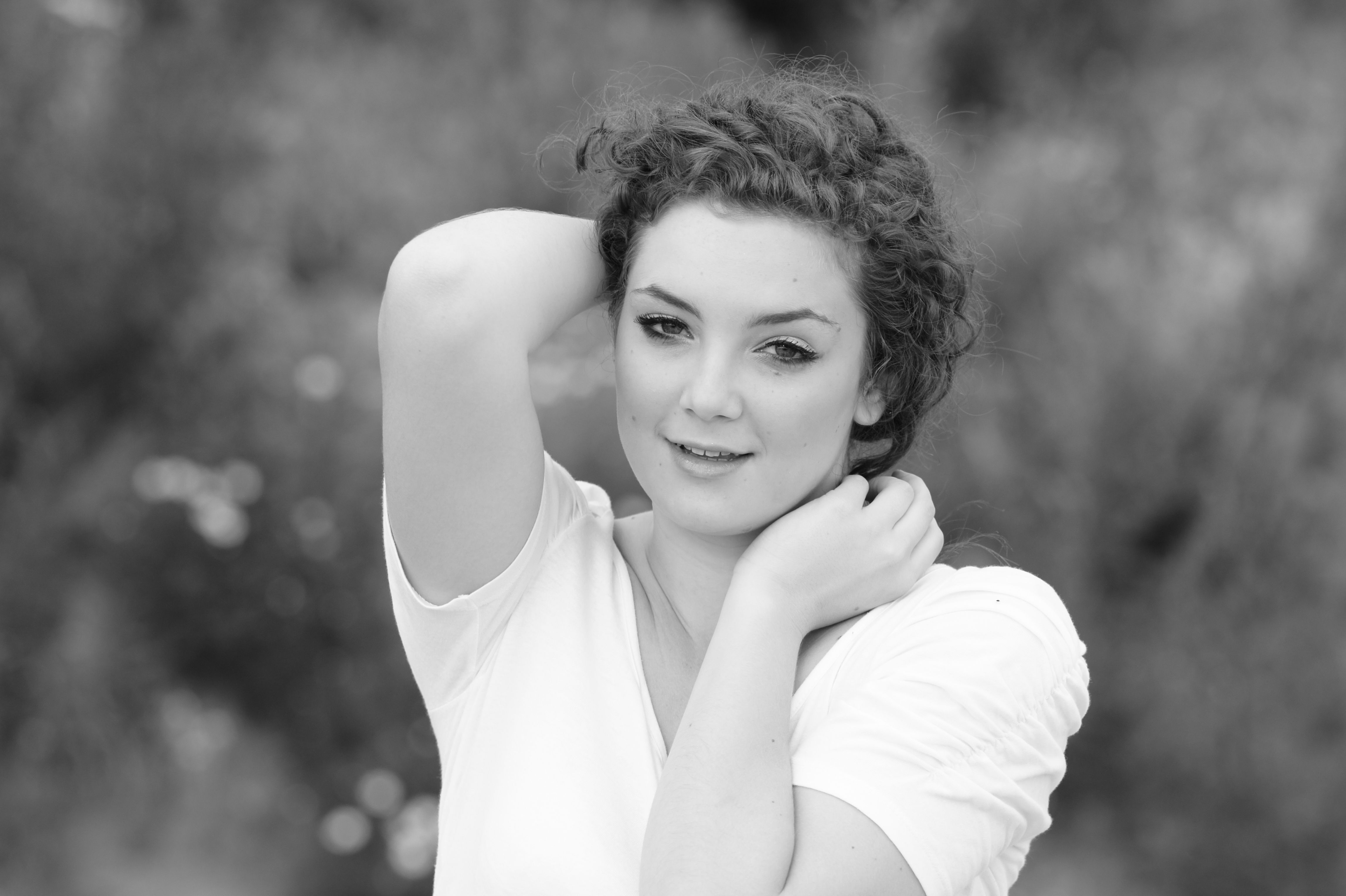 A woman in a white shirt posing for a black and white photo · Free ...
