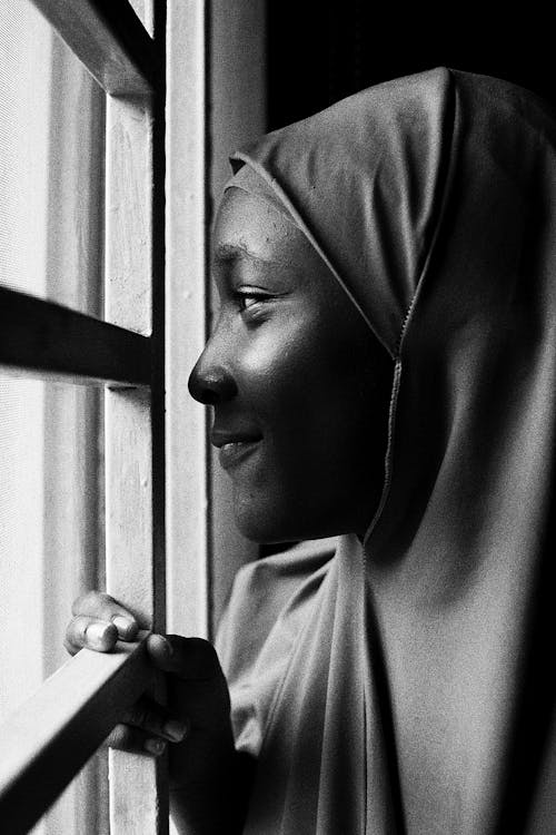 Face of Woman in Hijab Peeking through Window