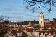 A beautiful view of Vilnius city featuring historic architecture and a prominent church tower under a clear sky.