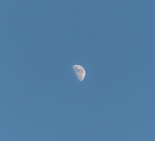 A moon is seen in the sky with a blue sky
