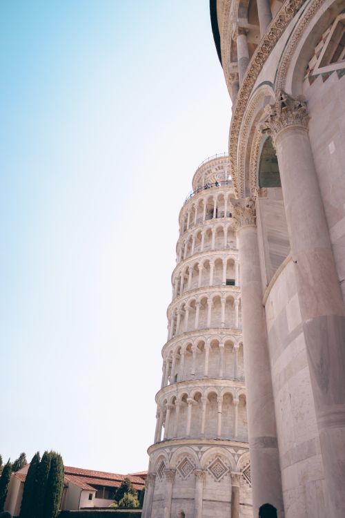 Free A captivating view of the iconic Leaning Tower of Pisa under a clear blue sky. Stock Photo