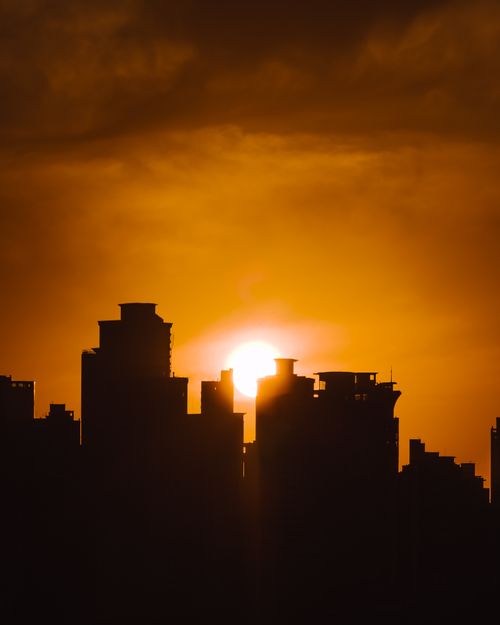 Free Beautiful sunset silhouette of Balneário Camboriú's skyline with a vibrant yellow sky. Stock Photo
