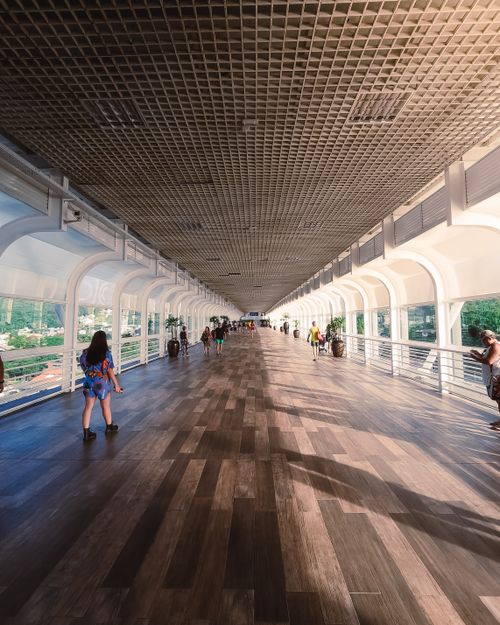 Free Sunny day on a modern footbridge in Balneário Camboriú, showcasing urban architecture and pedestrian activity. Stock Photo