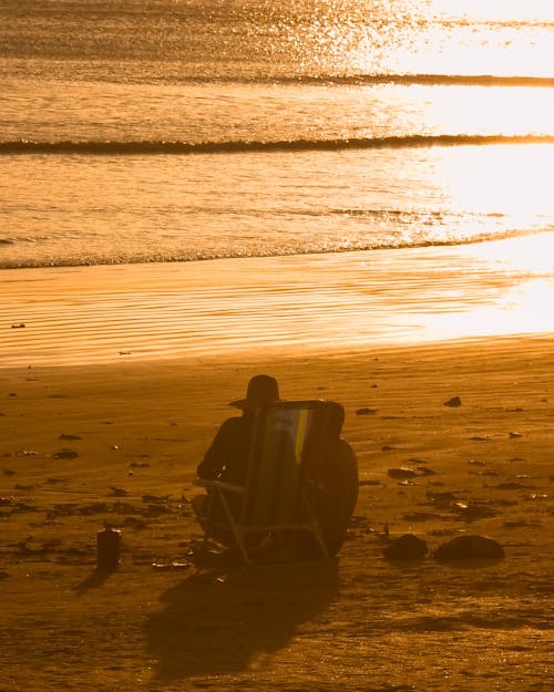 Couple Sitting on Beach at Sunset