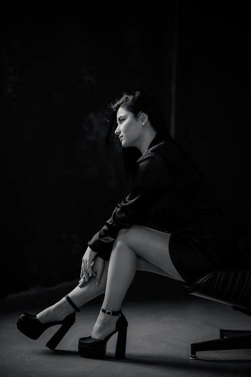 Woman Sitting in High Heels in Black and White