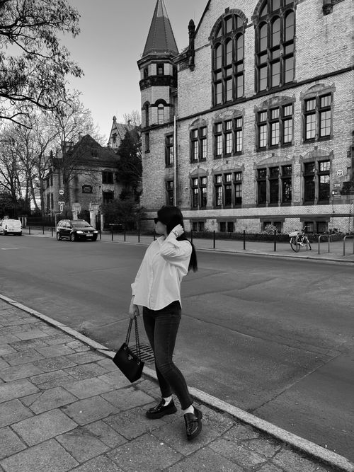 Free Fashionable woman poses on a city street in front of historic architecture. Stock Photo