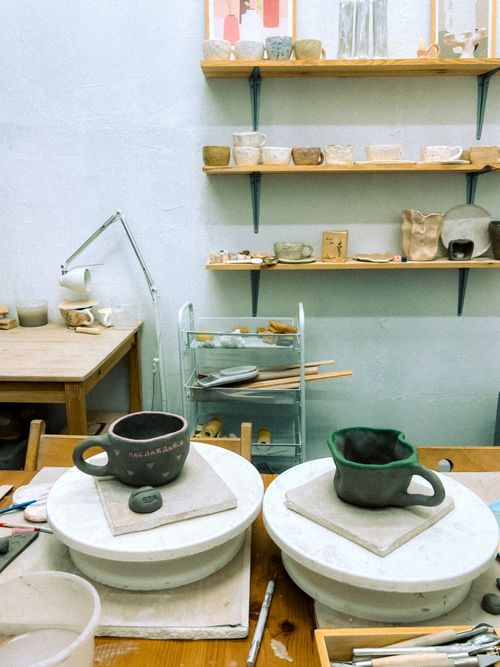 Pottery workshop with crafted mugs and clay tools — photo by Евгений Шухман on Pexels