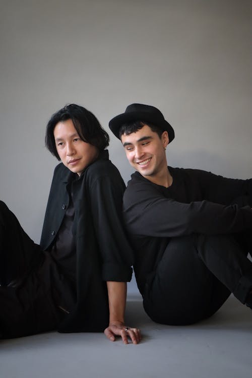 Smiling Men Sitting in Black Clothes