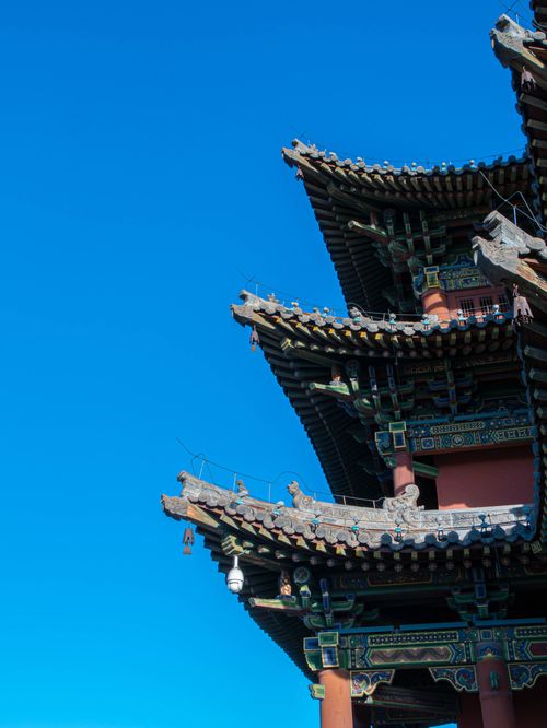 Free Detailed view of traditional Asian pagoda roof with intricate design against a clear blue sky, showcasing cultural architecture. Stock Photo