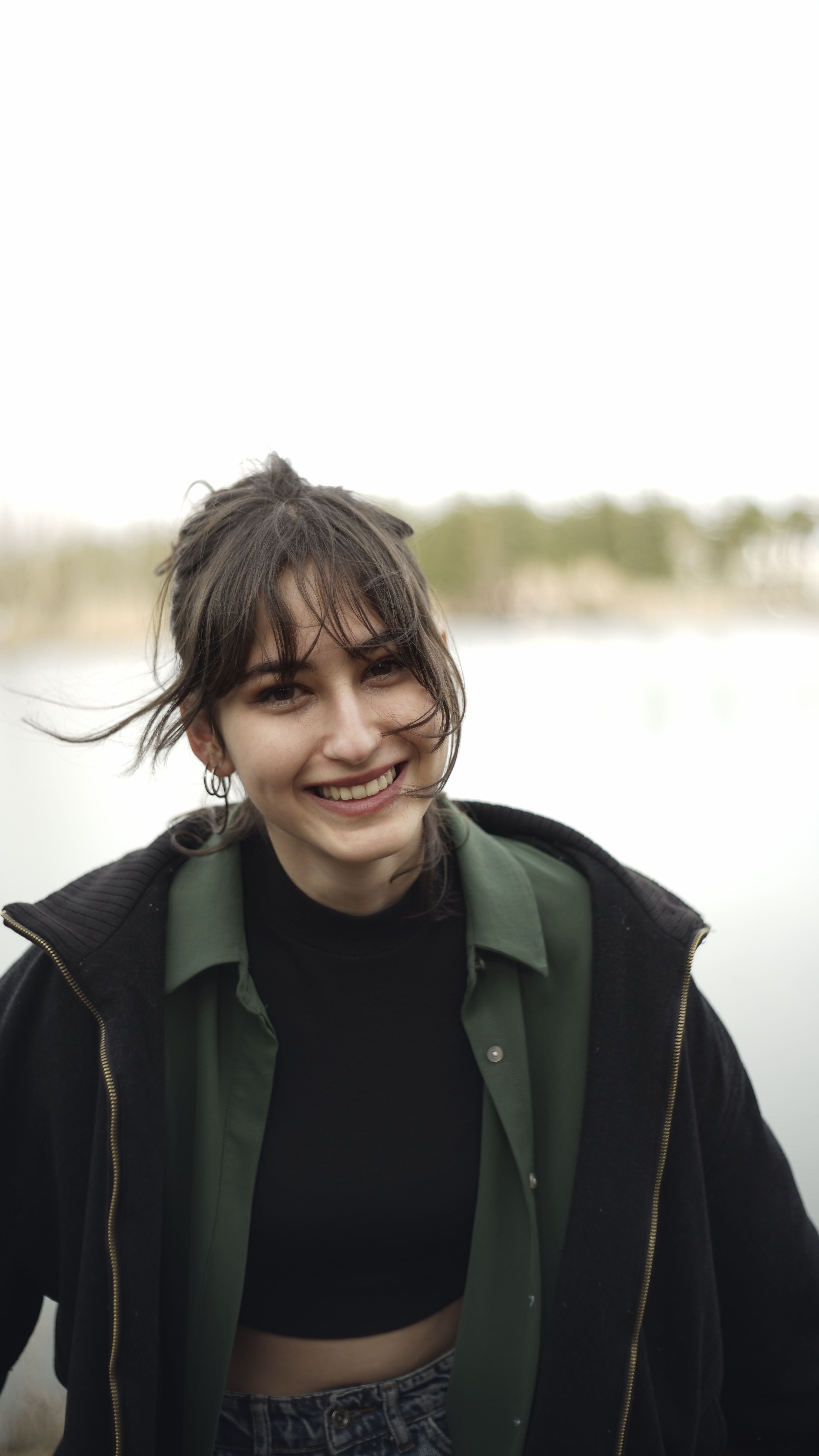 Portrait of a smiling young woman in Ankara, Turkey, with a natural outdoor backdrop.