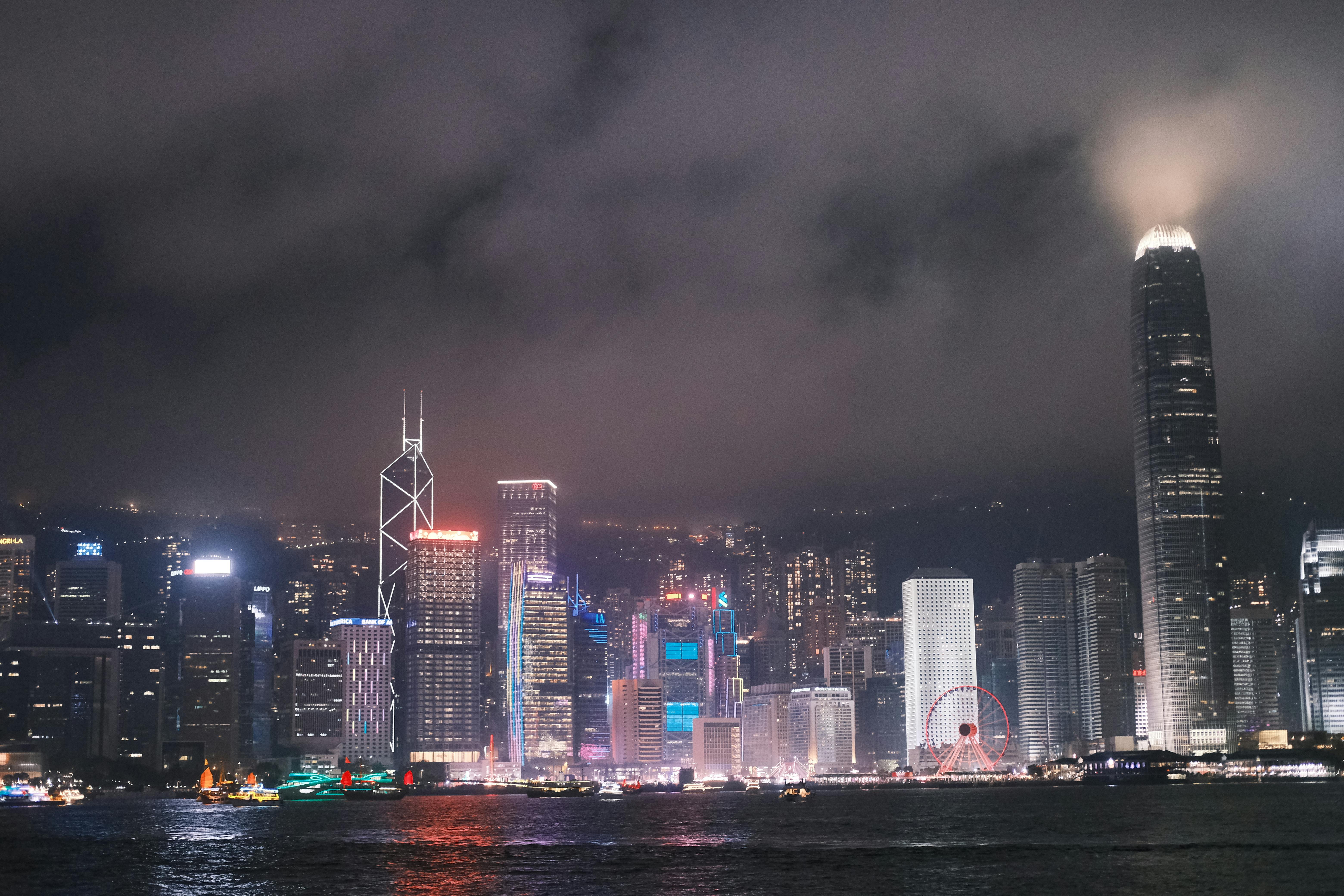 Illuminated Hong Kong skyline with iconic skyscrapers and Victoria Harbour at night.