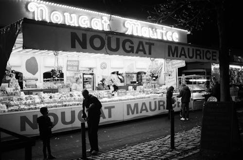 A black and white photo of a market at night