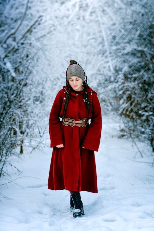 Woman in Red Coat Walking in Forest in Winter