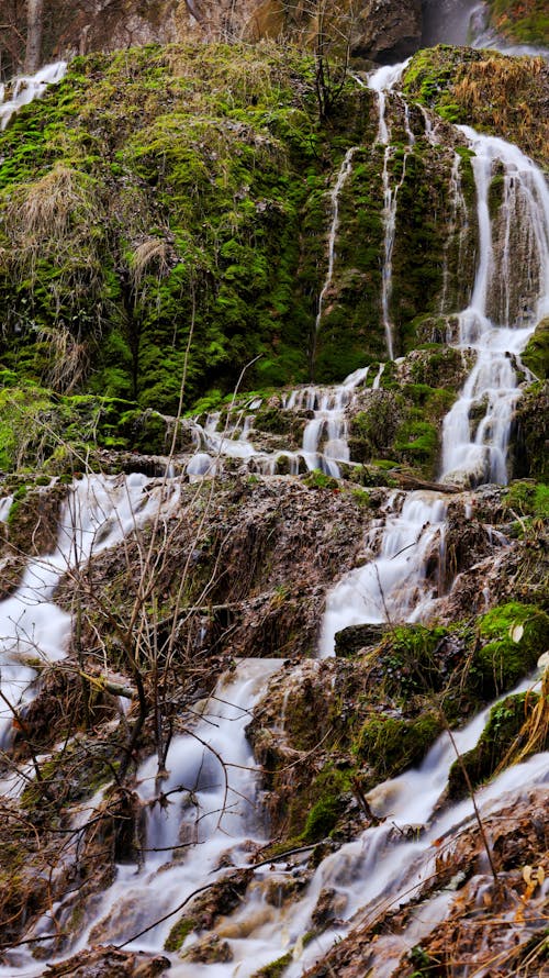 A waterfall is flowing down a hillside