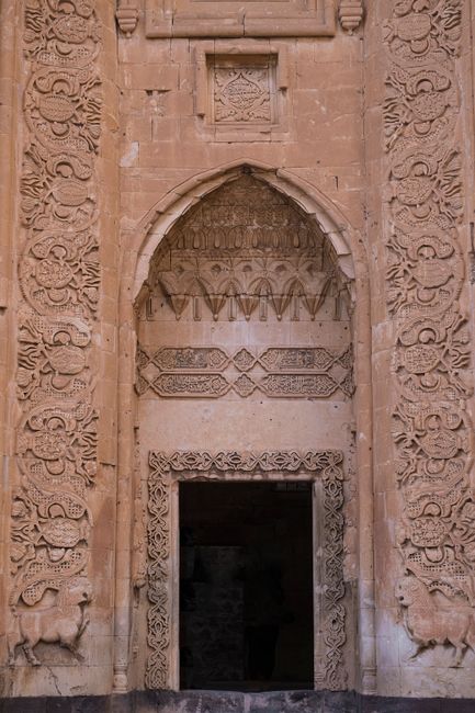 Intricate Ottoman architecture design of Ishak Pasha Palace's sandstone entrance in Turkey.