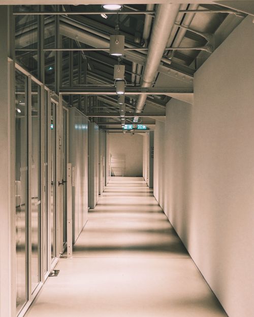Free Long modern corridor with glass doors in a stylish office building, showcasing architectural design. Stock Photo