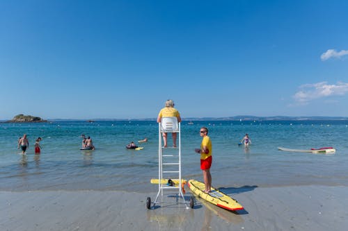 Lifeguards and People on Sea Shore in Summer
