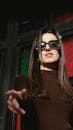 A Young Woman in Sunglasses Posing with Pointing her Fingers