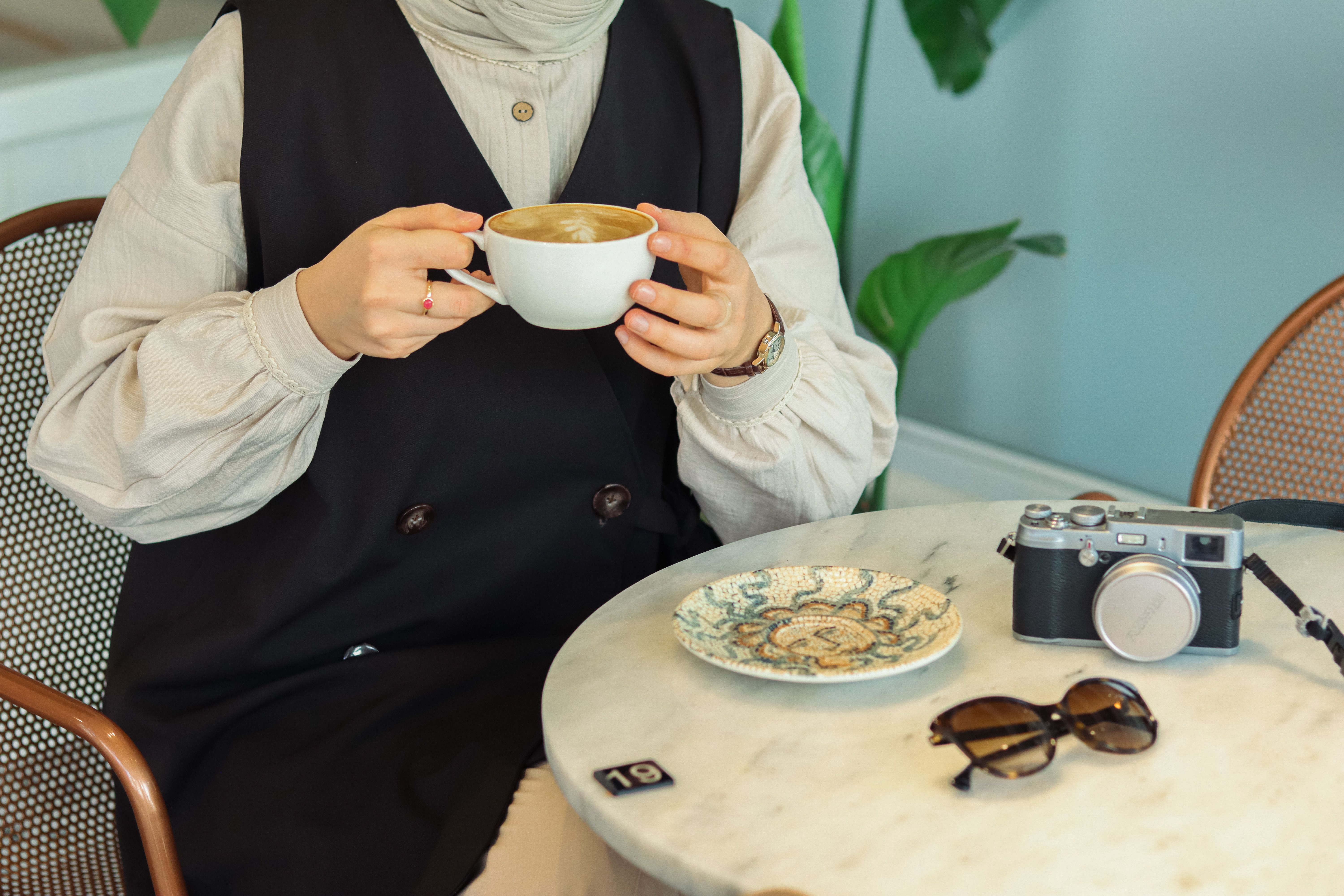 A woman in a hijab drinking coffee · Free Stock Photo