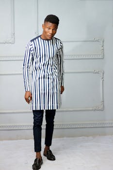 时尚男模特穿着条纹服装在室内摆姿势拍照