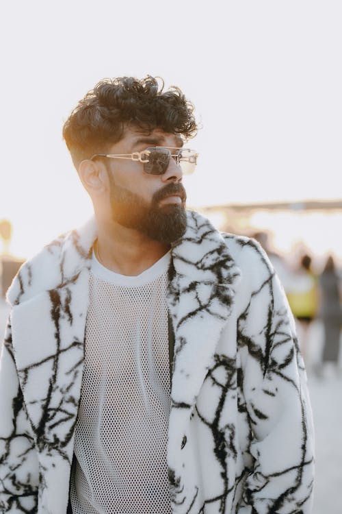 A man with a beard and glasses wearing a coat