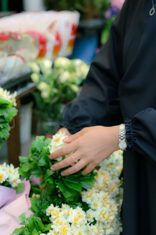 Free Close-up of a woman's hands arranging a chrysanthemum bouquet at a flower market. Stock Photo